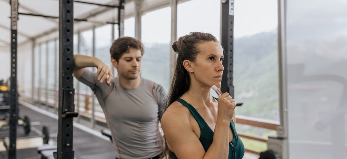 A fit couple engaged in gym exercises. Indoor workout with focus on fitness goals.
